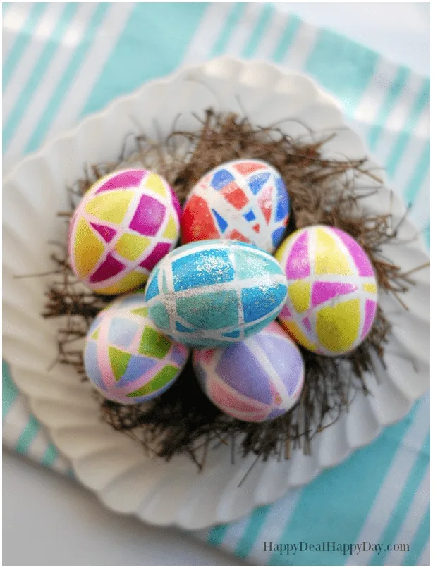 colorful Easter eggs on a wooden nest and white plate