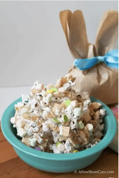 blue bowl with popcorn mix and brown paper bag in the shape of a bunny