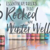 Essential oils good for winter wellness sitting by an essential oil roller bottle