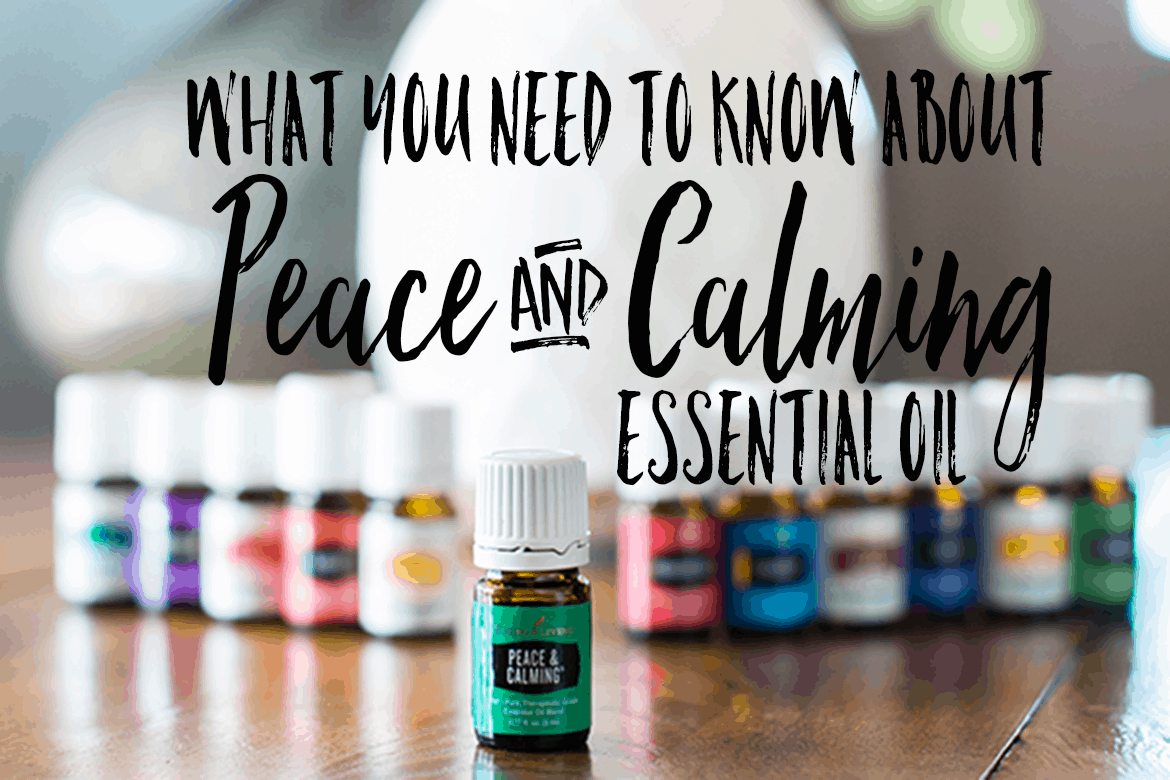 bottle of peace and calming essential oil with 11 other young living essential oils and a desert mist diffuser behind the oils. All are on a wooden table by a window with a plant