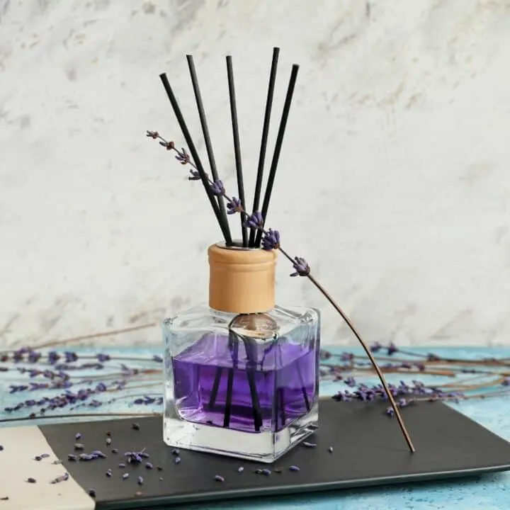 lavender DIY reed diffuser on a blue and black surface