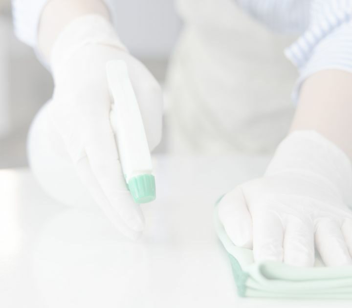 person using a spray bottle of homemade cleaning product made with essential oils